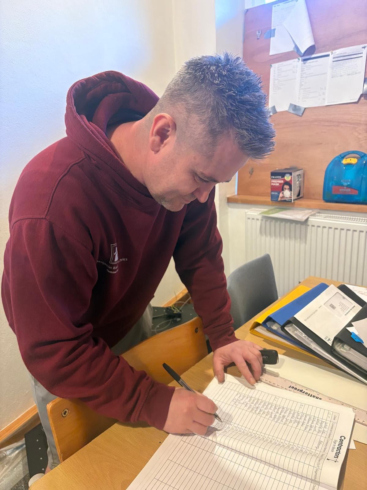 Benjamin Bailey completing a landlord Electrical Installation Condition Report on site, paperwork and certification underway.
