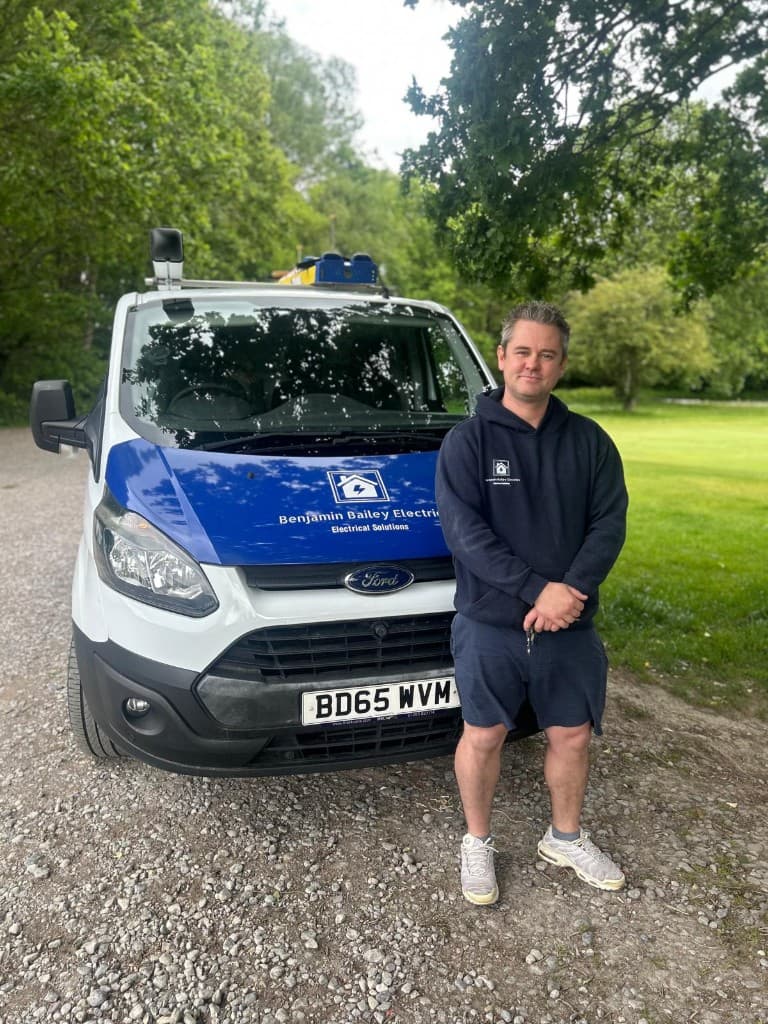 Benjamin Bailey beside his branded van, owner and qualified electrician at Benjamin Bailey Electrics