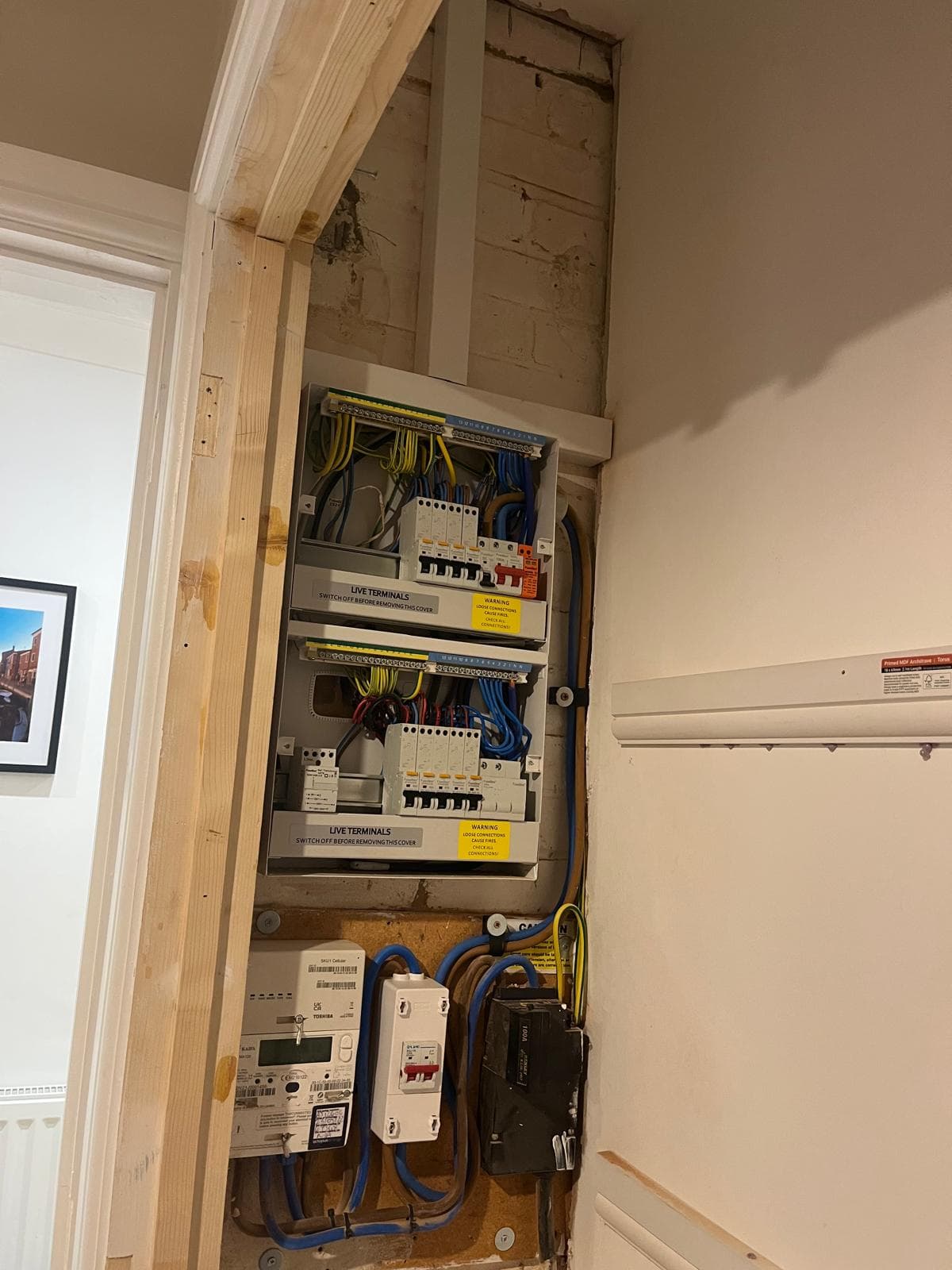A new metal-clad dual consumer unit installed in a hallway, with RCBO protection for each circuit.