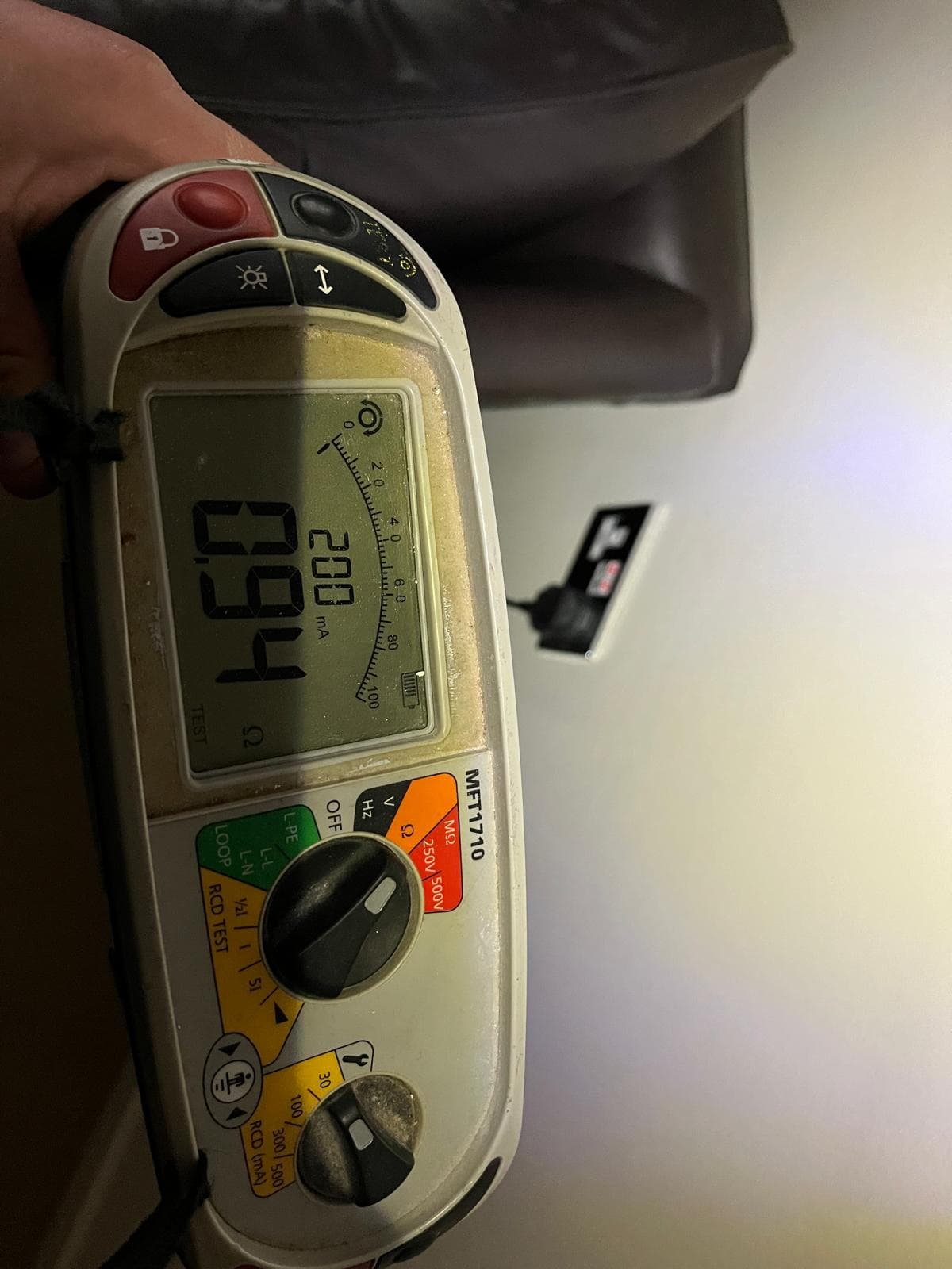 A calibrated multifunction tester connected to a consumer unit, recording readings during an Electrical Installation Condition Report.